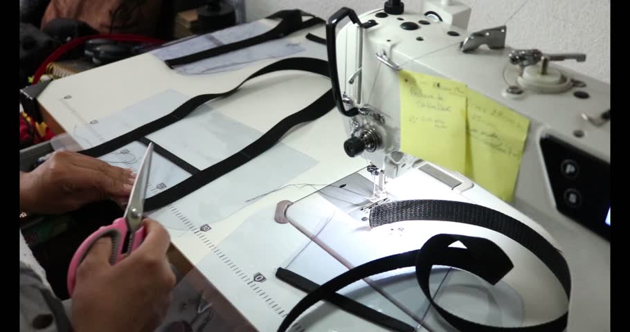 Latin mexican woman makin a bag and handles with her sewing machine at home as an entrepreneur in her free time like a part time job