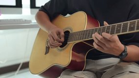 Close-up of a musician practicing fingerpicking on an acoustic guitar in a home studio environment, demonstrating musical skill and passion - Powered by Shutterstock - Get 15% off with code: PIKWIZARD15