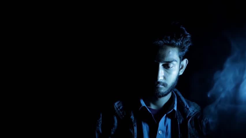 Cinematic Shot of a Hitman Sitting at a Table Holding a Gun with Dramatic Lighting — Intense and Mysterious Scene