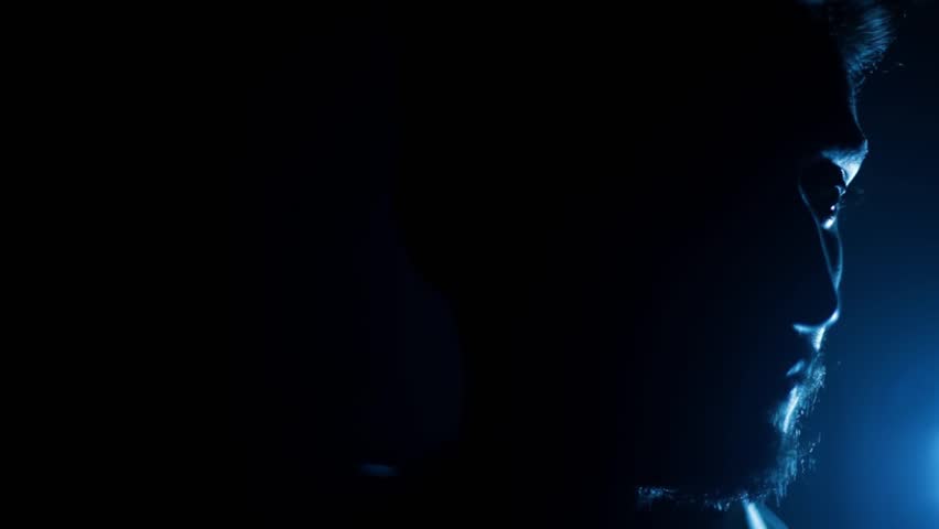 Cinematic Shot of a Man Sitting on a Chair with Dramatic Lighting on Half of His Face — Intense and Mysterious Atmosphere | HD Footage