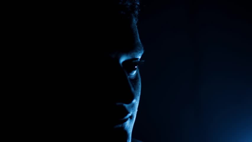 Cinematic Shot of a Man Sitting on a Chair with Dramatic Lighting on Half of His Face — Intense and Mysterious Atmosphere | HD Footage