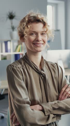 Portrait of smiling female company owner in background of modern cozy office. Footage of gorgeous Caucasian woman in classy clothes looking at camera. Indoors, business people concept, daytime