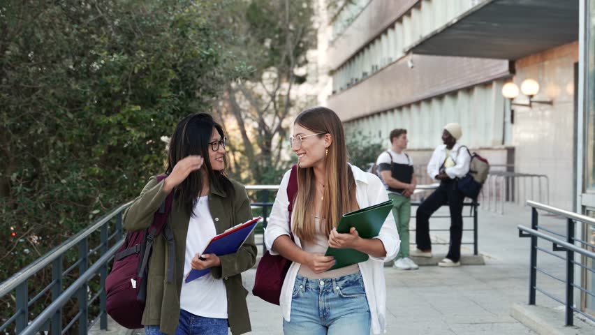Happy College student girl friends talking and walking to University School. Diverse Asian and American Youth