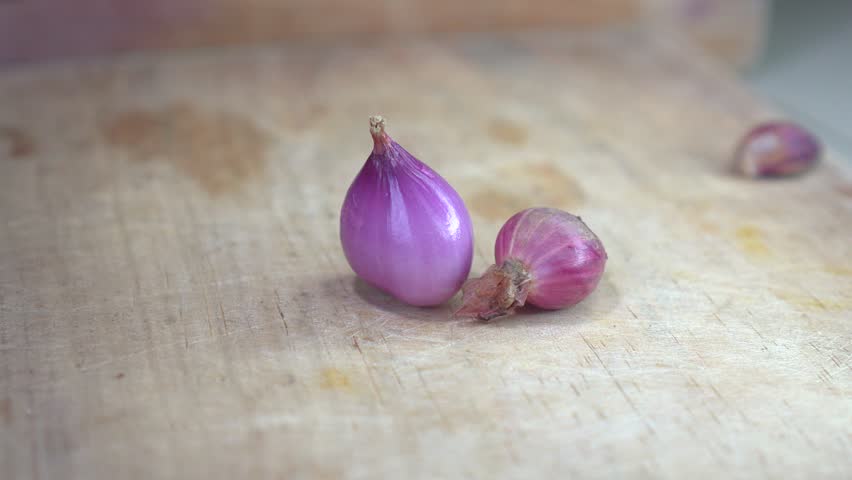 Video thumbnail featuring a simple still life of red onions on a wooden surface. Focus on fresh produce and natural ingredients