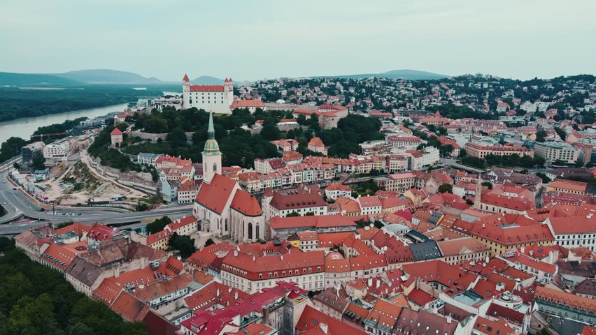 Panoramic aerial view of Bratislava, Slovakia. Historic old town of European city with red-roofed buildings and St Martins Cathedral surrounded by hills