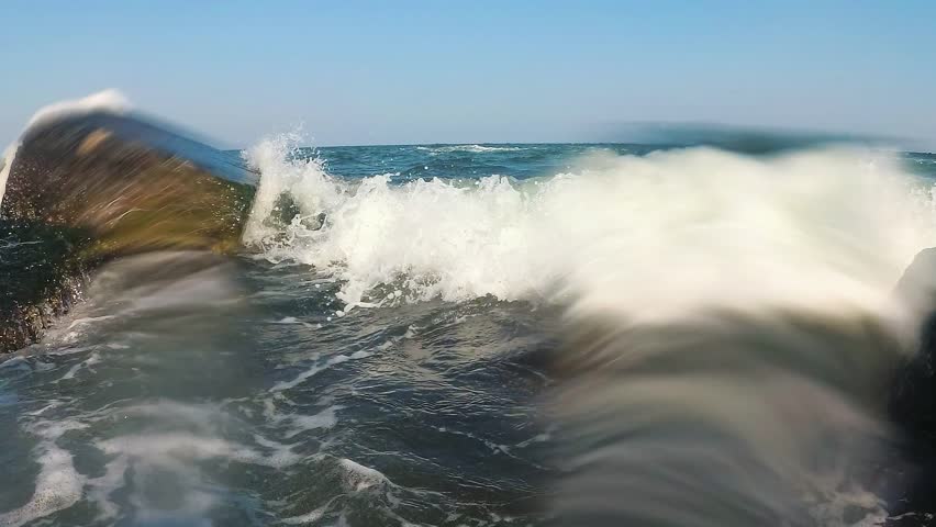 Storm in the Black Sea, waves splashing among rocks near the shore, water hitting the camera, Odessa