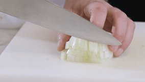 A chef is cutting a white onion with a large knife on a white kitchen board. Slow motion footage 100fps. - Powered by Shutterstock - Get 15% off with code: PIKWIZARD15