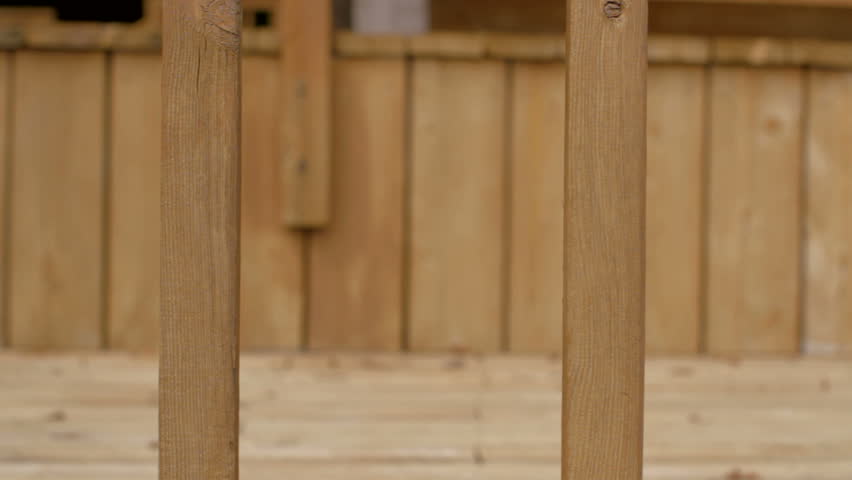 Detail of wooden railings on a back porch. Dolly move from left to right.