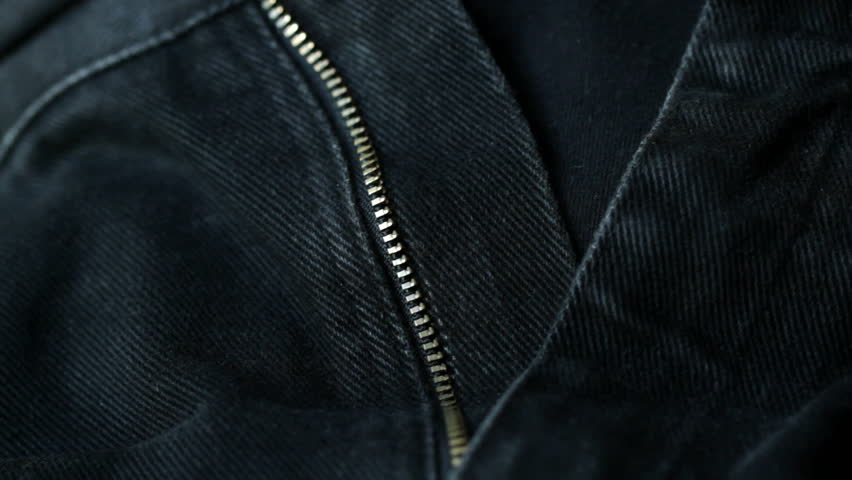 Zipping up the fly on a pair of blue denim jeans. Side view, shot with a macro
