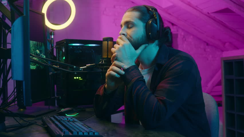 Frustrated pensive Caucasian influencer man thinking gamer talking upset addicted vlogger playing computer game guy streamer gaming decision cyber sport at home male contemplating blog blogger stream