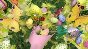 Yellow feathers blown by soft wind from the top over a colorful Easter festive decoration with tulips, decorated eggs, butterflies, paper umbrellas, and yellow feathers on a daisy-themed background. - Powered by Shutterstock - Get 15% off with code: PIKWIZARD15