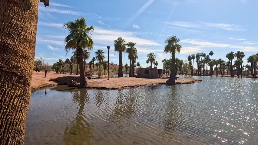 footage of a gorgeous landscape at Papago Park with a lake, lush green palm trees and rocks in Phoenix Arizona USA