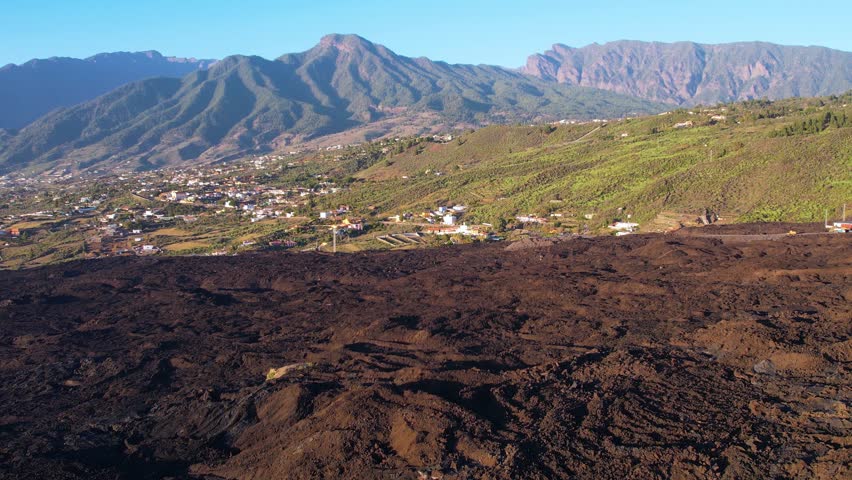 Aerial lava and crater of Cumbre Vieja volcano two years after eruption with houses of small town on La Palma island Canary Islands Spain