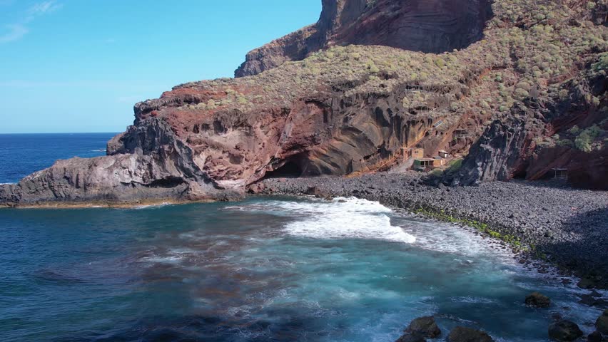 Aerial of small fishing pirate village carved into the rocks on ocean shore on La Palma island Canary