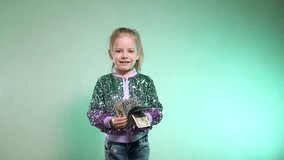 Happy girl throws up cash. Paper dollar currency dances around a delighted girl. Money rains down on a happy child, whose arms are raised in exhilaration against a bright backdrop. Slow motion shootin - Powered by Shutterstock - Get 15% off with code: PIKWIZARD15