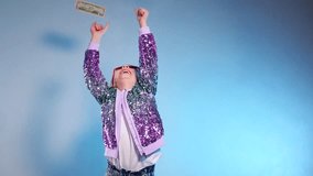 Happy girl throws up cash. Paper dollar currency dances around a delighted girl. Money rains down on a happy child, whose arms are raised in exhilaration against a bright backdrop. Slow motion shootin - Powered by Shutterstock - Get 15% off with code: PIKWIZARD15