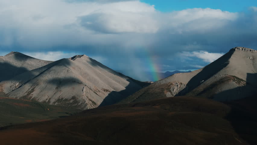 Rainbow Behind The Churchward Hill Mountain In Ogilvie Mountain Range In Yukon, Canada. - aerial shot