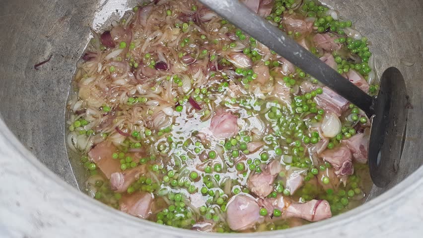 Cooking Meat with Onions and Green Spices in a Large Pot