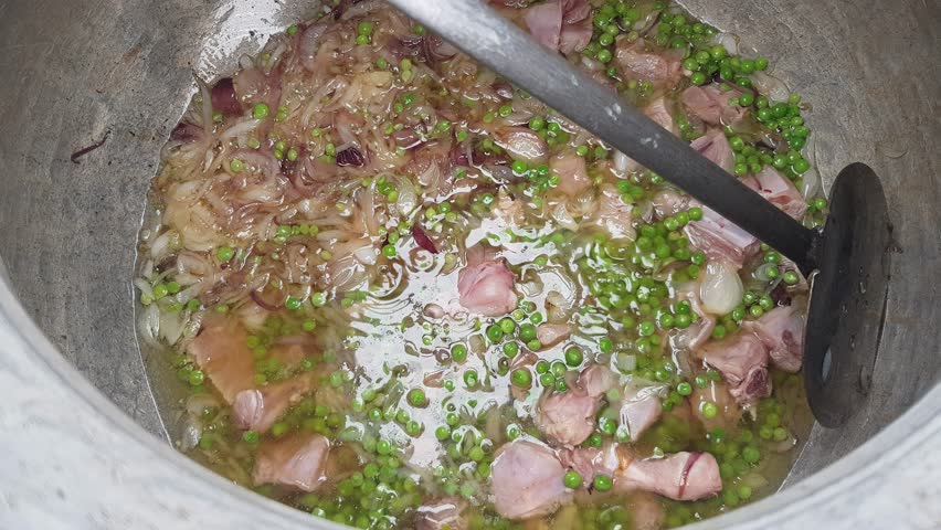 Cooking Meat with Onions and Green Spices in a Large Pot