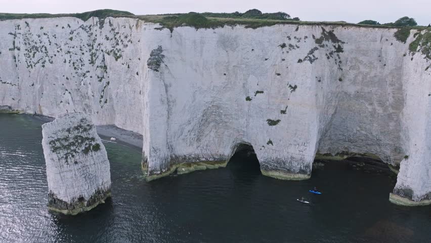 Old Harry Rocks with people in Kayak swimming past cliff faces