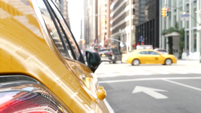 New York City. Yellow taxi car on Manhattan street. Taxi cab on Midtown Lexington avenue. Medallion taxicab rear view on Lex ave waiting for people or passengers on road. Urban scene in United States.
