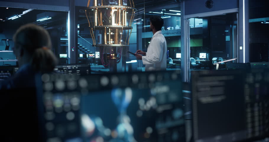 Computer Screen with Molecular Modelling Software with Animated Chemical and Biological Structures are Managed. Focus Switching to an Indian Scientist with a Tablet Working with a Quantum Computer