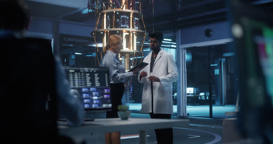 Diverse Male and Female Engineers Collaborating on a Quantum Computing Project, Analyzing Data on a Tablet Computer. Team Working Together on Building a Quantum Processor in a Research Center