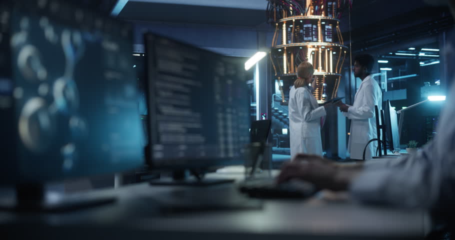 Female and Male Engineers Working in an Advanced Lab. Technician and Manager Discussing Quantum Computing Technology for Medical Research. Molecular Modelling Software Working on Computer Screen