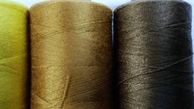 A detailed close-up of multicolored threads ranging from brown to gold, showcasing fine texture and shimmering fibers. The vibrant colors highlight the beauty of textile craftsmanship. - Powered by Shutterstock - Get 15% off with code: PIKWIZARD15
