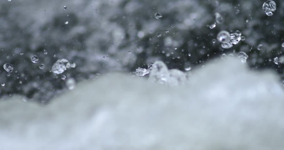 Close-up footage of turbulent river rapids in slow motion.