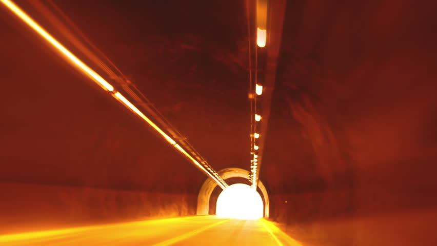 Driving through a dark mountain tunnel and coming out into bright light. 