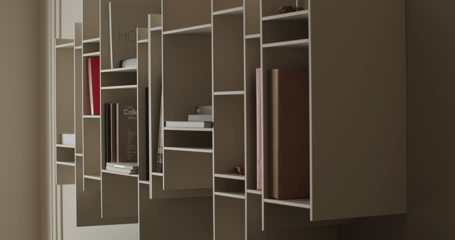 A sleek and modern minimalist bookshelf filled with books and decorative items. Perfect for contemporary interior design and stylish home organization. Neutral tones and clean lines.