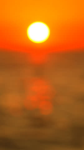Sunset Ocean Sunrise Beach: Vibrant orange sunset over calm ocean waters at dawn, capturing tranquil scene.
