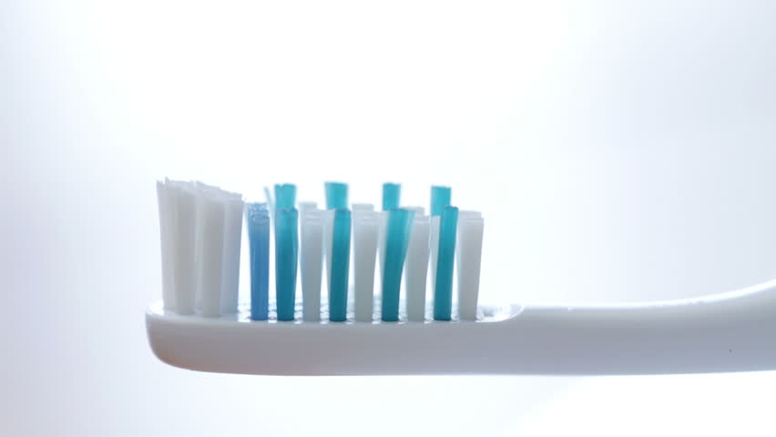 Detail of toothpaste being squeezed on to a toothbrush. Two clips.