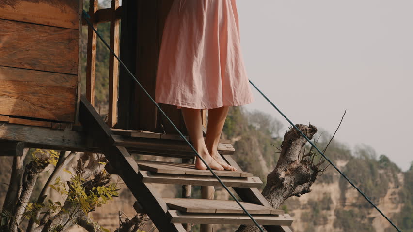 Woman standing on stairs of famous treehouse Nusa Penida