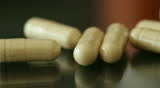 Dollying across pills/dietary supplements on a glass surface. Extreme close-up