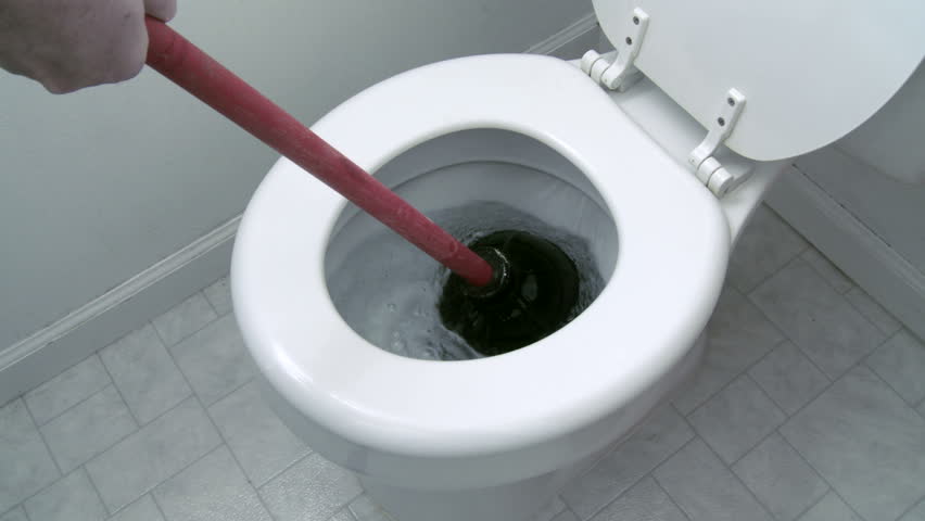 Using a plunger in an attempt to unclog a toilet. Close view with clean water in