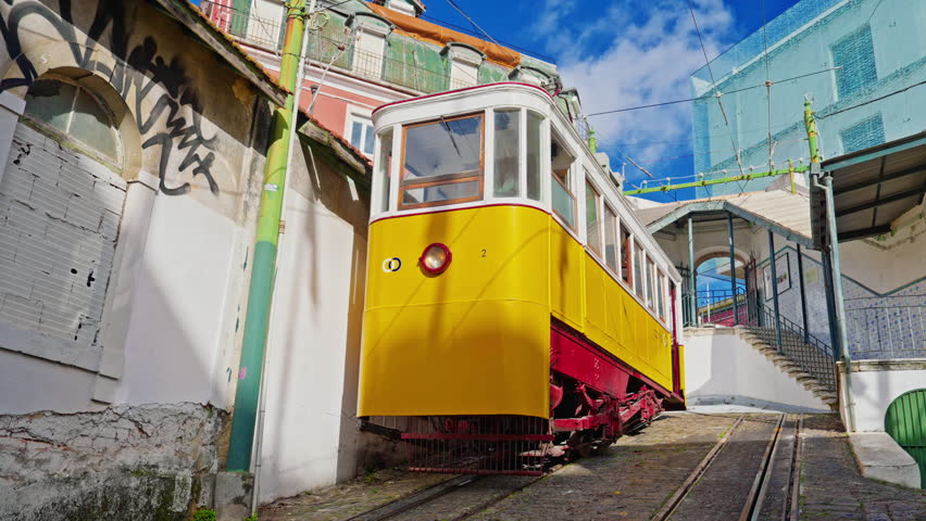 Lisbon, Portugal, 26 February 2025: The old yellow tram, funicular on the narrow street in Lisbon