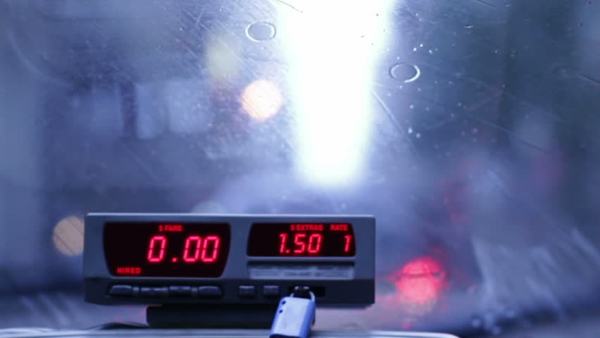 Taxi meter runs up a $100 fare on a very short trip. Rainy streets visible