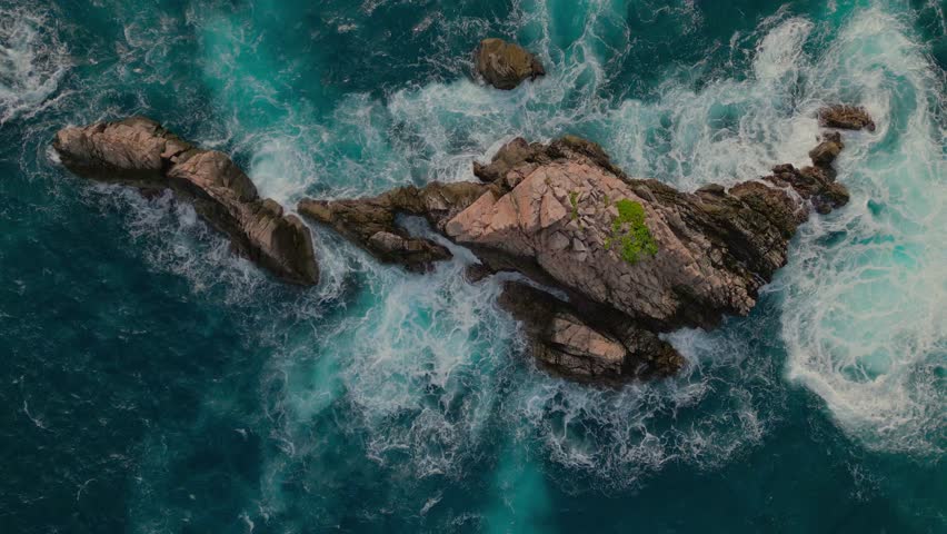 A drone view of jagged rock formations and crashing waves from above at Sharks Teeth Beach in kelumbayan, lampung, Indonesia