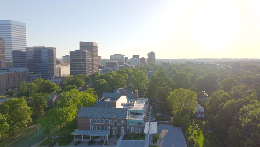 Aerial shot moving forward with a pan toward modern office buildings in downtown Clayton, St. Louis, Missouri. The dynamic movement captures the city’s skyline and corporate district on a clear day