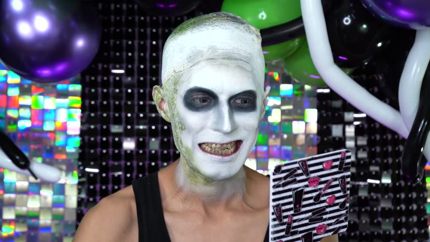 Close-up shot of actor applying darkening agent to teeth, character performing stage. SFX Makeup