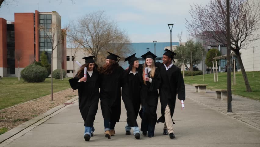 Multi ethnic graduated students walking together in their university campus