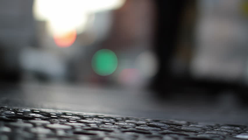 Low angle view of the sidewalk with blurred focus on pedestrians walking in the