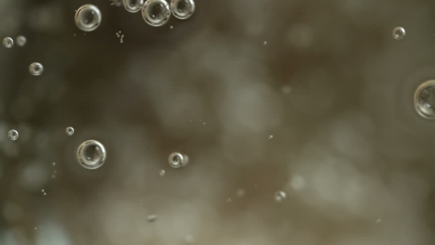 Looking down into a glass of clear soda. Extreme close-up recorded with macro