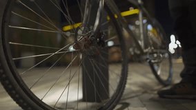 Man wearing helmet and medical mask cycles through city at night, stops by a streetlight, takes off his helmet, and hangs it on the bikes handlebar, highlighting urban pollution and health issues.  - Powered by Shutterstock - Get 15% off with code: PIKWIZARD15