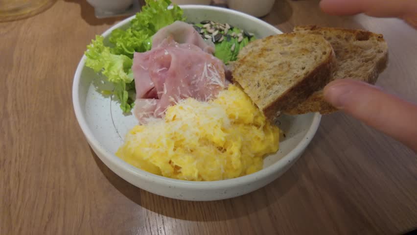 Healthy breakfast in restaurand. scrambled eggs with ham and avocado