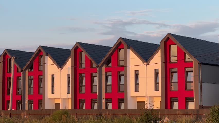 Modern Red and White Townhouses in Row at Sunset with Blue Sky Background