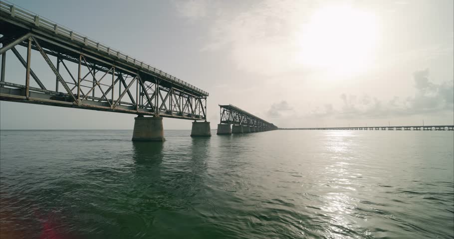Wide static shot of old bridge and new bridge in Florida Keys from Bahia Honda. Traffic seen driving on bridge. For projects requiring longer clips in higher resolution, visit StockPlates.
