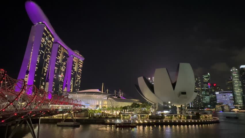 View of Marina Bay Singapore at night with colorful light from hotels and buildings around Marina Bay.